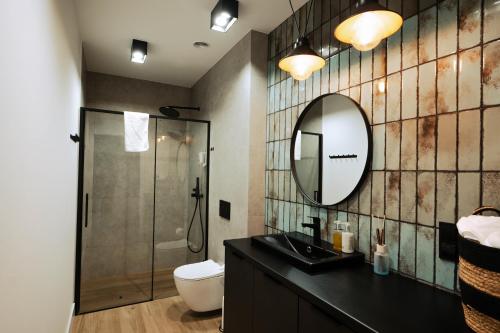 a bathroom with a shower and a sink and a mirror at Apartamenty Fuleda nad jeziorem Dobskim Mazury Holiday in Fuleda