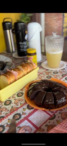 a table with a plate of hot dogs and a chocolate cake at Hostel Chapada Dos Guimarães in Chapada dos Guimarães
