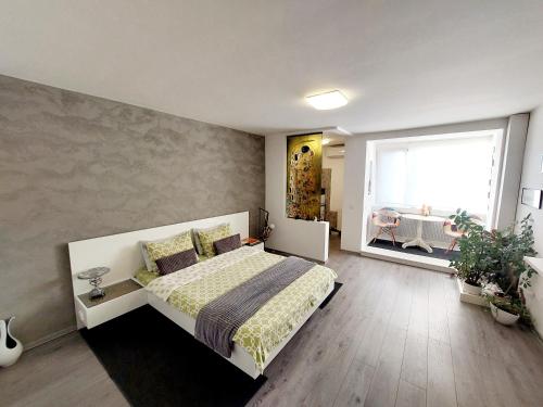 a bedroom with a bed and a large window at The Kiss Apartment in Timişoara