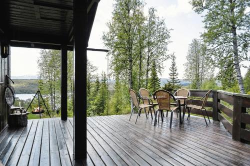 a wooden deck with chairs and a table on it at Mountain Cabin With Great Views in Austbygdi