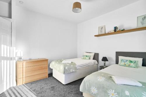 a bedroom with two beds and a dresser in it at Craigs Nook in Darlington