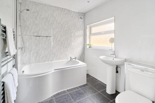 a white bathroom with a tub and a sink at Craigs Nook in Darlington