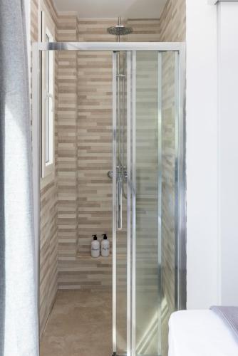a shower with a glass door in a bathroom at Naxos Cube Villa Panoramic Views Maisonette with Sea View 2 min walk to Plaka Beach in Plaka