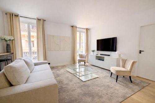 a living room with a white couch and a tv at Luxury Elegance Comfort 3-room apartment of 80m2 with 2 BDR 2 BA 3 min Croisette & Beach in Cannes
