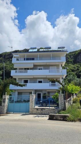 a large white building with a fence in front of it at Vila Riand in Borsh