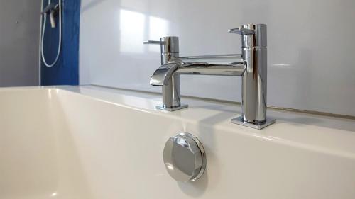 a bathroom sink with a faucet and a mirror at Tigh Na Sith in Aultbea