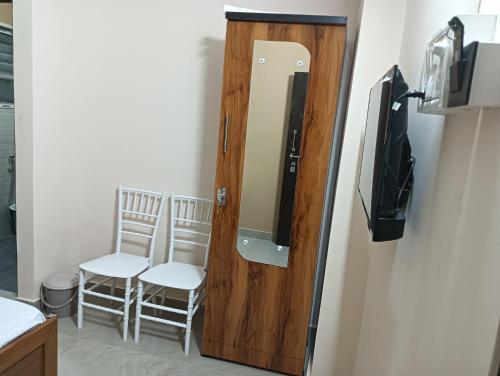 a door with a mirror and two chairs in a room at Swagat Lodge in Chāngsāri