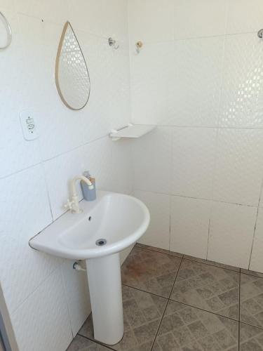 a bathroom with a white sink and a mirror at Suíte Externa Casal in Rio das Ostras