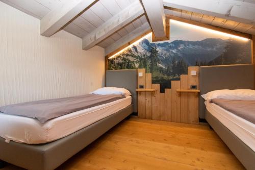 two beds in a room with a large window at Livigno Chalets in Livigno