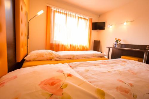 two beds in a room with a window at Hotel Franz Anton in Sargans
