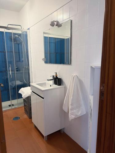 a white bathroom with a sink and a shower at Casa do Profeta in Porto Santo
