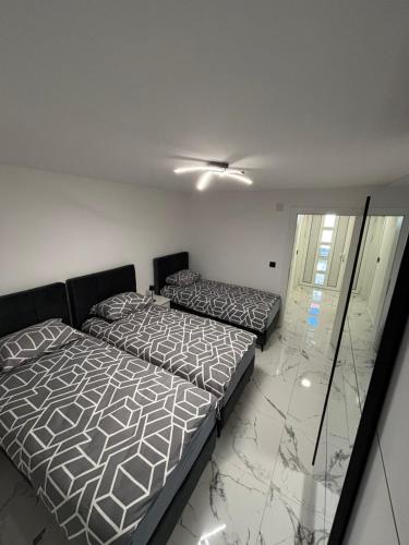 a bedroom with two beds and a ceiling at Apartman Miljanic in Vlasenica