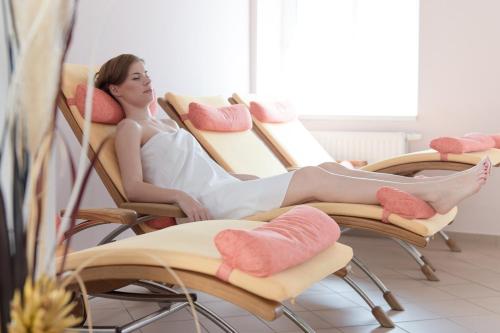 a woman sitting on a chair in a salon at Grand Hotel Rogaška Premium in Rogaška Slatina