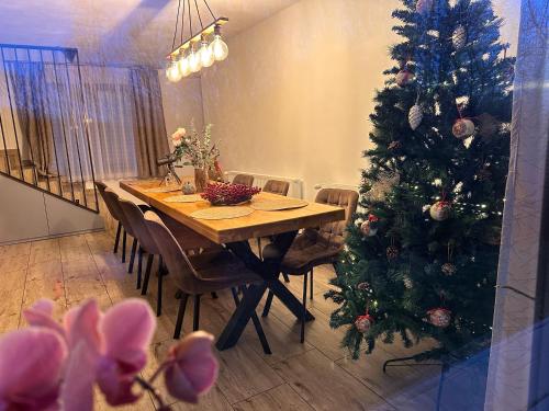 a dining room with a table and a christmas tree at Cabana Dintre Fagi in Poiana Mărului
