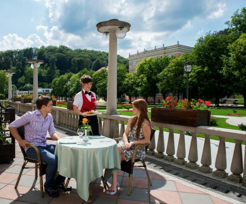 a group of people sitting around a table on a patio at Grand Hotel Rogaška Premium in Rogaška Slatina