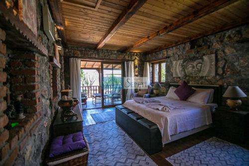 a bedroom with a large bed in a stone wall at Kaya Koy Deluxe Villas Fethiye in Fethiye