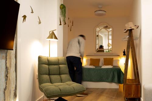a man is making a bed in a room at Judería Suite Jaén in Jaén