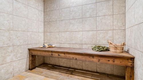 a room with a wooden bench in a tiled wall at HotTub Sauna Pool Table Views Mins to Downtown Gatlingburg Hollows Haven in Gatlinburg