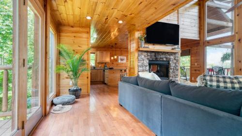 a living room with a couch and a fireplace at HotTub Sauna Pool Table Views Mins to Downtown Gatlingburg Hollows Haven in Gatlinburg
