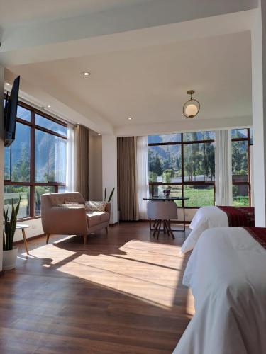a bedroom with a bed and a couch and windows at Florez de la Villa Apartments & Suites in Cusco