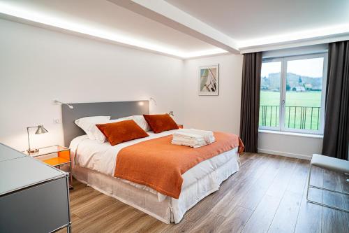 a bedroom with a bed and a large window at Les Sources du Val in Saint-Pierre-du-Val