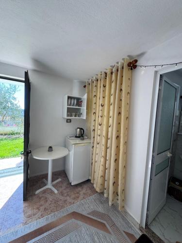 una stanza con una cucina con un tavolo e delle tende di Hillside Haven a Durrës