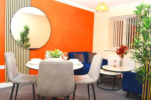 a dining room with a table and chairs and a mirror at Warrington Suites by Relax Stays in Warrington