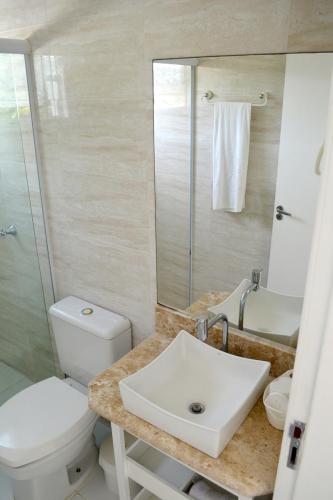 a bathroom with a white toilet and a sink at Hospedaria Canto do Morro in Bombinhas