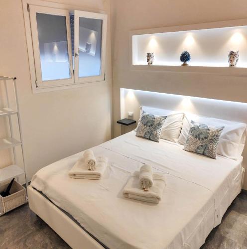 a bedroom with a large white bed with towels on it at Il Rifugio in Marettimo