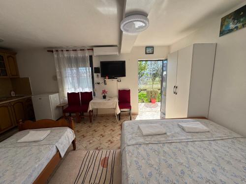 una camera da letto con due letti, un tavolo e una televisione di Hillside Haven a Durrës