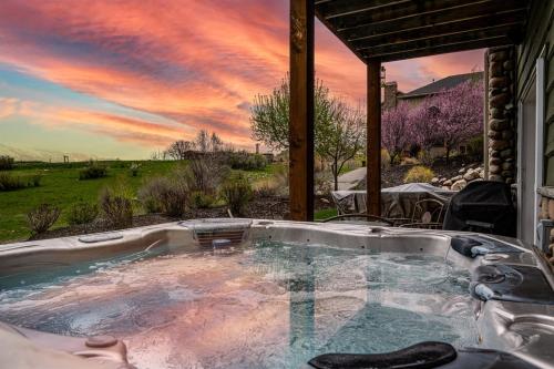 a jacuzzi tub with a sunset in the background at Snowcrest C304Ski Getaway Hot Tub & Theater Room in Eden
