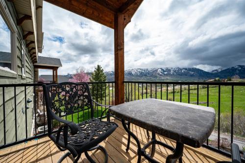 a table and chair on a porch with a view of mountains at Snowcrest C304Ski Getaway Hot Tub & Theater Room in Eden