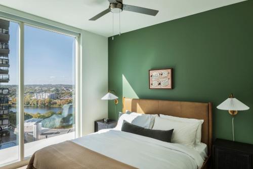 a bedroom with a bed and a large window at ROOST Rainey in Austin