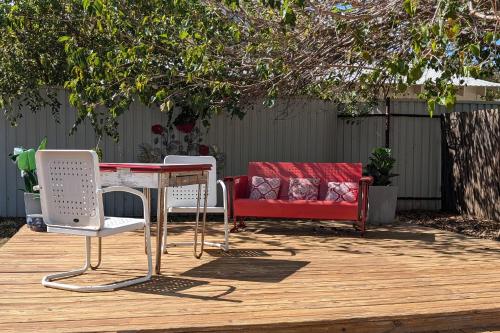 a patio with a red couch and a table and chairs at The Mason House in Georgetown