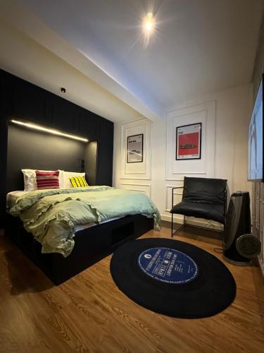 a bedroom with a bed and a chair and a rug at The Hive Apartments - The Forge Unit in Lagos