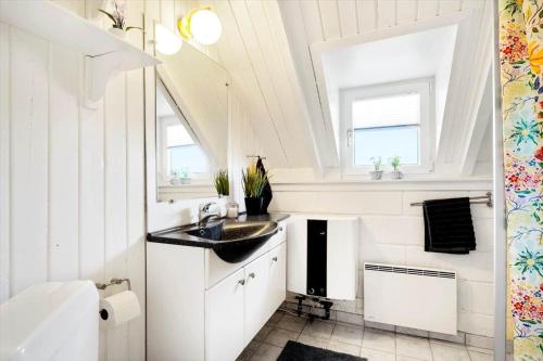 a white bathroom with a sink and a toilet at 2289-Ringkobing-Nordso-Ferievej-21 in Klegod