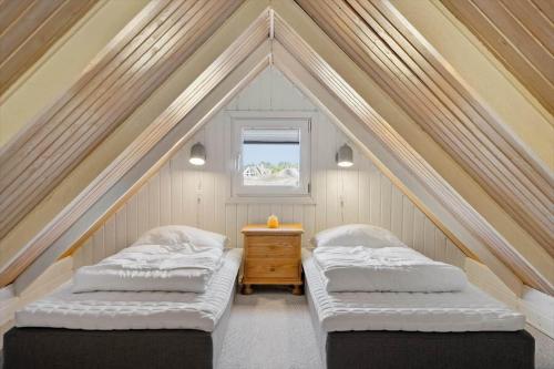 two beds in a attic room with a window at 2289-Ringkobing-Nordso-Ferievej-21 in Klegod