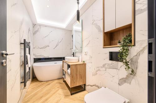 a bathroom with a tub and a toilet and a sink at KOA - Signature Collection in Braşov