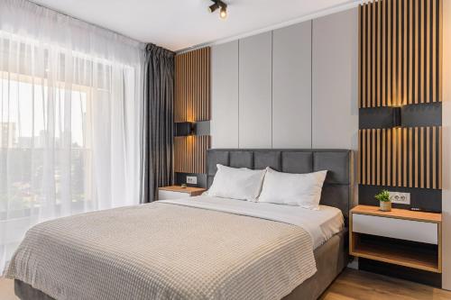 a bedroom with a bed and a large window at KOA - Signature Collection in Braşov