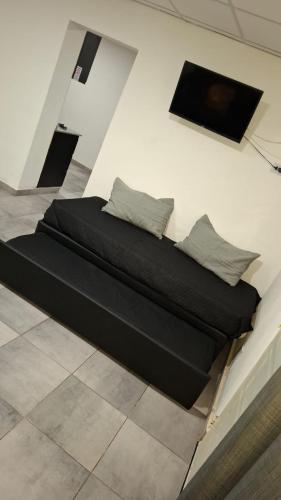 a black bed with two pillows on a wall at Sisters Place in Guaymallen