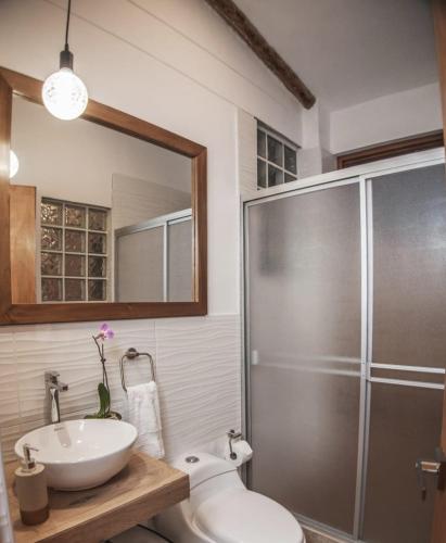 a bathroom with a toilet and a sink and a shower at Florez de la Villa Apartments & Suites in Cusco