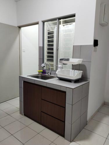 a kitchen with a sink and a window at IJM Suria Homestay in Sandakan