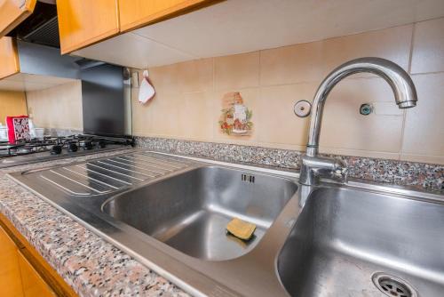a kitchen with a stainless steel sink and a stove at Il Melograno, appartamento privato in Cavriago