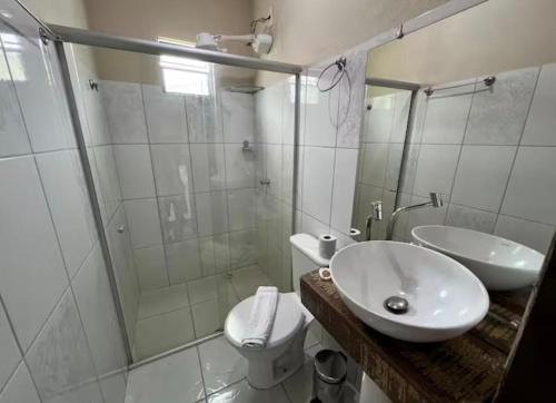 a bathroom with a toilet and a sink and a shower at Pousada Casa Rosa in Itacaré
