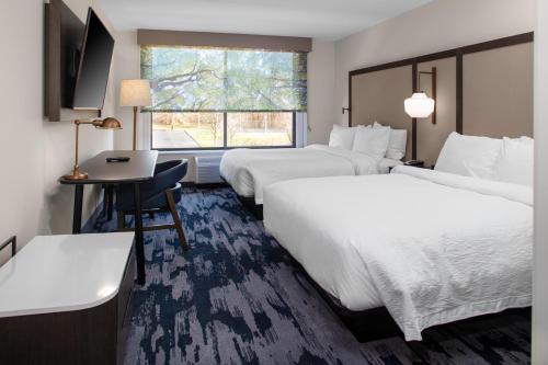 a hotel room with two beds and a desk at Fairfield Inn & Suites Springfield Enfield in Springfield