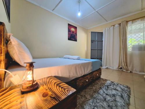 a bedroom with a bed and a table with a lamp at Janari Homes in Diani Beach