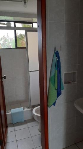 a bathroom with a toilet and a towel on the wall at Hotel La Tolita in Atacames