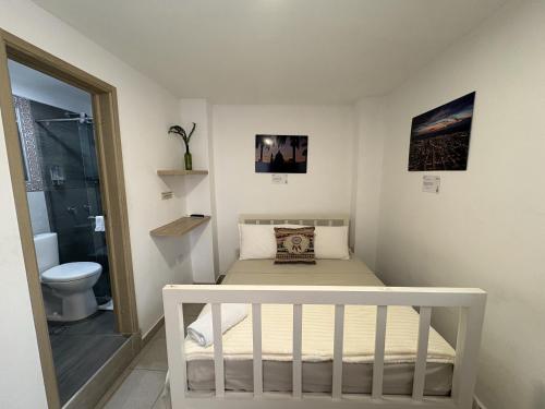 a small bedroom with a bed and a toilet at Casa Mompa in Bucaramanga