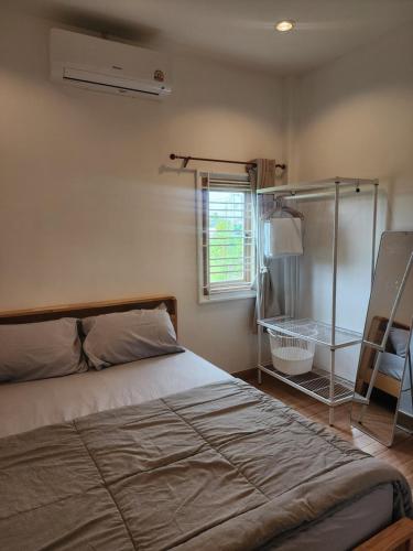 a bedroom with a bed and a window at 19 House in Ban Khlong Pleo