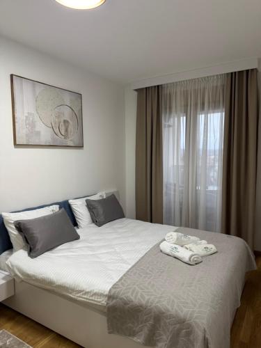 a bedroom with a large bed with towels on it at Tilia Lux Wellnes &Spa in Čačak